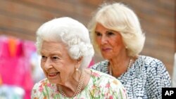 FILE - Britain's Queen Elizabeth II and Camilla, Duchess of Cornwall, at the G-7 summit in Cornwall, England, June 11, 2021.