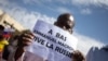 FILE - A man holds up a sign reading 'Down with Emmanuel Macron, long live Russia' during a mass demonstration in Bamako, on Jan. 14, 2022. 