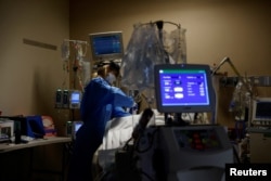 FILE - Medical staff treat a COVID-19 patient in the Intensive Care Unit at the Providence Mission Hospital in Mission Viejo, California, Jan. 25, 2022.