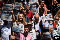 Para pengunjuk rasa memegang foto perwakilan RSF yang dipenjara di Istanbul, Turki. (Foto: AFP)