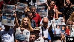 FILE - Protesters hold pictures of jailed Reporters Without Borders representative Erol Onderoglu, journalist Ahmet Nesin and rights activist Sebnem Korur Fincanci as they shout slogans in front of the Pro Kurdish Ozgur Gundem newspaper's headquarters, in Istanbul, June 21,2016.