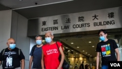 FILE - Koo Sze-yiu (in red) leaves following a court hearing in Hong Kong, Sept. 30, 2020 (Tommy Walker/VOA)
