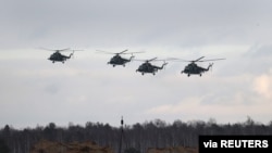 Belarusian military helicopters fly during the joint exercises of the armed forces of Russia and Belarus at a firing range in the Brest Region, Belarus, Feb. 3, 2022. 