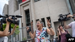 FILE - Human rights activist Sebnem Korur Fincanci flashes victory sign in front of Istanbul's courthouse, July 17, 2019.