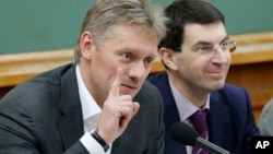 FILE - Russian President Vladimir Putin's spokesman Dmitry Peskov, left, speaks during a meeting in Moscow, Russia. 