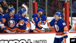 FILE- New York Islanders center Josh Ho-Sang (66) celebrates his goal against the Philadelphia Flyers with teammates in the third period of a preseason NHL hockey game in New York., Sept. 26, 2016.