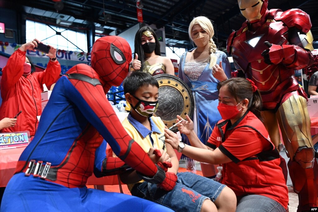 Performers dressed as superhero characters comfort a child who is receiving the Pfizer-BioNtech Covid-19 vaccine for children aged 5-11 at a gym in San Juan City, suburban Manila, Philippines.