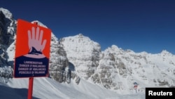 FILE: An avalanche warning sign is posted next to the slope at Schlick 2000 ski resort near Neustift im Stubaital, Austria, Feb. 6 2020. 