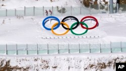 Biathletes skate above the Olympic rings during practice at the 2022 Winter Olympics, Feb. 3, 2022, in Zhangjiakou, China. 