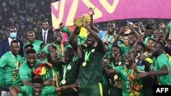 Senegal's players celebrate with the trophy after winning the Africa Cup of Nations 2021 final football match between Senegal and Egypt at Stade d'Olembe in Yaounde, Cameroon, on Feb. 6, 2022.