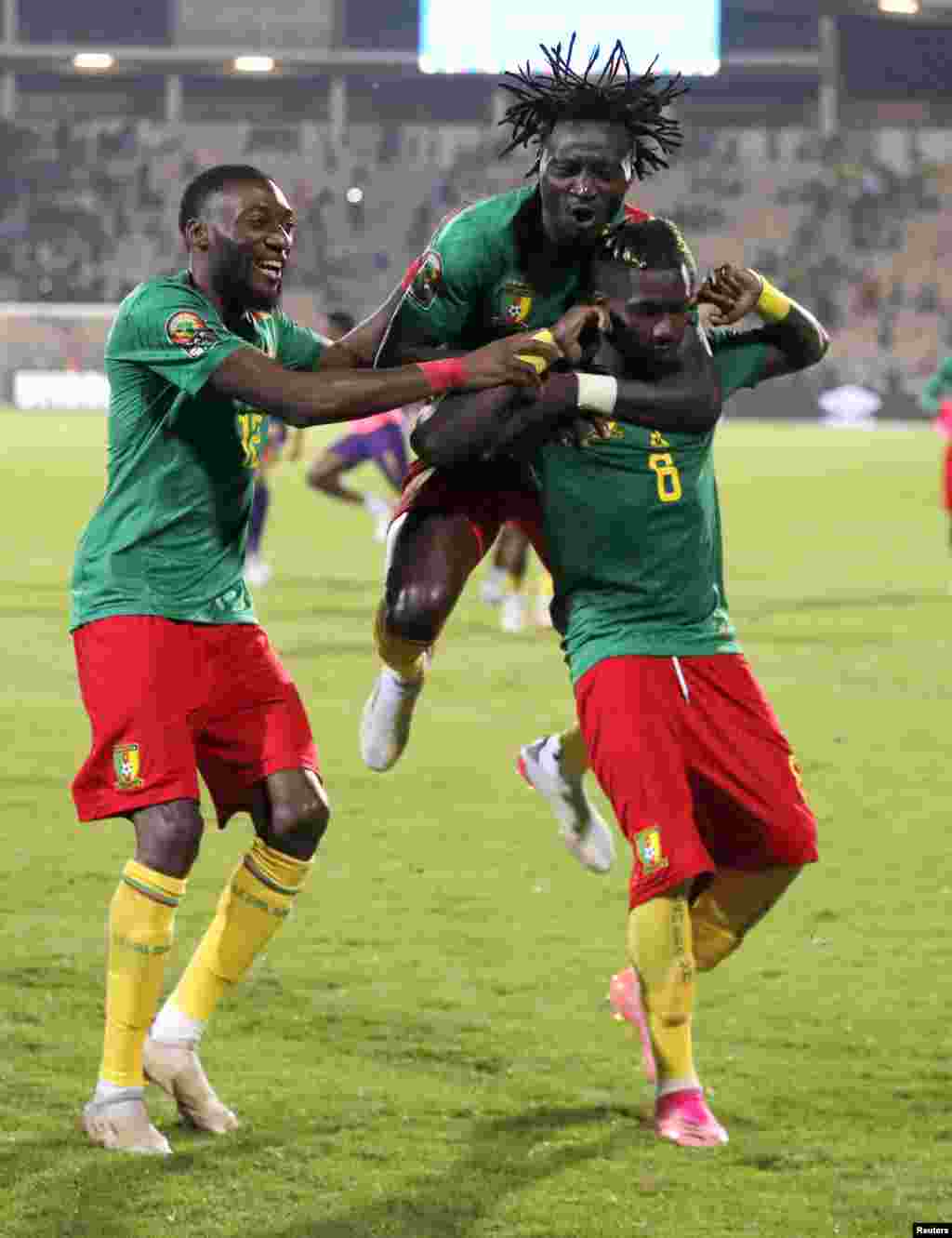 Cameroon&#39;s Ambroise Oyongo Bitolo celebrates with teammates after scoring the winning penalty in the shoot-out against Burkina Faso.