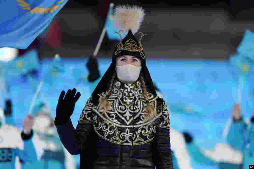 Yekaterina Aidova, of Kazakhstan, waves as she walks into the stadium during the opening ceremony of the 2022 Winter Olympics, Feb. 4, 2022, in Beijing.