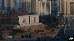 FILE - Portraits of late North Korean leaders Kim Il Sung and Kim Jong Il sit in downtown Pyongyang, North Korea.