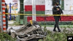 La policía camina cerca de los restos de un coche bomba que explotó cerca de una estación de policía en Padilla, Cauca, Colombia, el domingo 6 de febrero de 2022.
