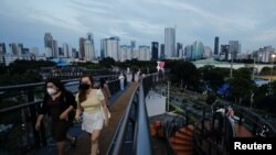 Warga mengenakan masker saat berjalan-jalan di sepanjang jembatan skywalk di tengah merebaknya varian Omicron di Jakarta, 7 Februari 2022. (REUTERS/Willy Kurniawan).