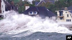 FILE - Waves slam along the shore near high tide as the remnants of Hurricane Ida leave Massachusetts, Sept. 2, 2021, in Scituate, Mass.