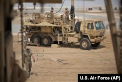 FILE - U.S. Army troops work near a Patriot missile battery at Al-Dhafra Air Base in Abu Dhabi, United Arab Emirates, May 5, 2021.