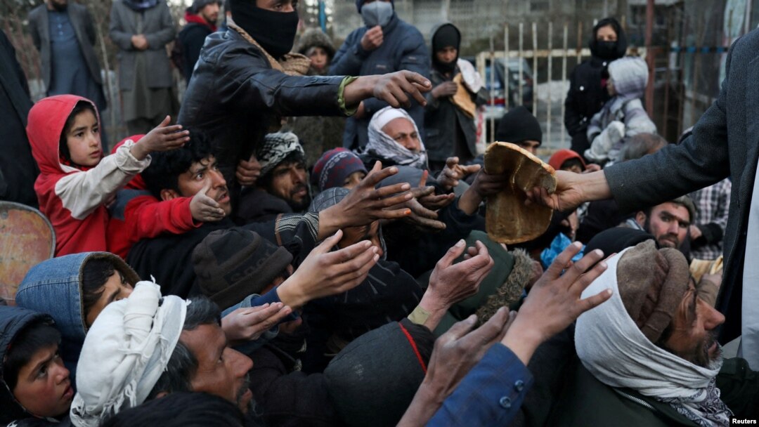 People reach out to receive bread in Kabul, Afghanistan, Jan. 31, 2022.
