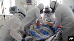 Medical staff members wearing special suits to protect against coronavirus treat a patient with coronavirus at an ICU of the Clinical hospital in Volgograd, Russia, Jan. 31, 2022. 
