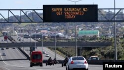 FILE - A sign on an Auckland motorway urges people to get vaccinated at a COVID-19 vaccination clinic during a single-day vaccination drive, in Auckland, New Zealand, Oct. 16, 2021. 