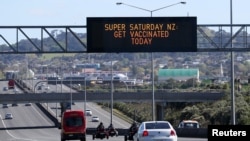 FILE - A sign on an Auckland motorway urges people to get vaccinated at a COVID-19 vaccination clinic during a single-day vaccination drive, in Auckland, New Zealand, Oct. 16, 2021.