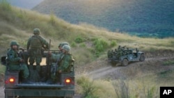 FILE - Soldiers patrol near the hamlet Plaza Vieja in the Michoacan state of Mexico, Oct. 28, 2021.