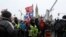 FILE - Police officers stand among protesters in front of Parliament Hill as truckers and their supporters continue to rally against COVID-19 restrictions and vaccine mandates, in Ottawa, Canada, Feb. 6, 2022.