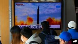 FILE - People watch a TV showing a file image of a North Korean missile launch during a news program at the Seoul Railway Station in Seoul, South Korea, Jan. 30, 2022.