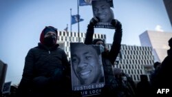 Demonstrators hold photos of Amir Locke during a rally protesting his killing during a police raid, outside the Hennepin County Government Center in Minneapolis, Minnesota, Feb. 5, 2022. 