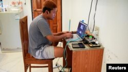Journalist Min Het Mone, whose parents cut ties with him, works in his room, at Thai-Myanmar border, Jan. 26, 2022. 