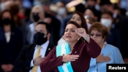 La nueva presidenta de Honduras, Xiomara Castro, levanta el puño mientras canta el himno nacional durante su ceremonia de juramentación en el Estadio Nacional de Tegucigalpa, Honduras, el 27 de enero de 2022.