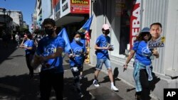 Personas distribuyen propaganda electoral en San José, Costa Rica, el martes 18 de enero de 2022. Las elecciones para elegir al presidente se realizarán el 6 de febrero. (Foto AP/Carlos González)