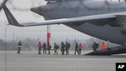 Efectivos de la 82ª División Aerotransportada del Ejército de Estados Unidos descargan vehículos de un avión tras arribar el domingo 6 de febrero de 2022 al aeropuerto Rzeszow-Jasionka, en el sureste de Polonia. 