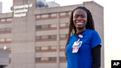 In this Feb. 1, 2022, photo provided by University of Louisville Hospital, Faith Akinmade, an ICU nurse from Nigeria, poses for a photo in front of the hospital.