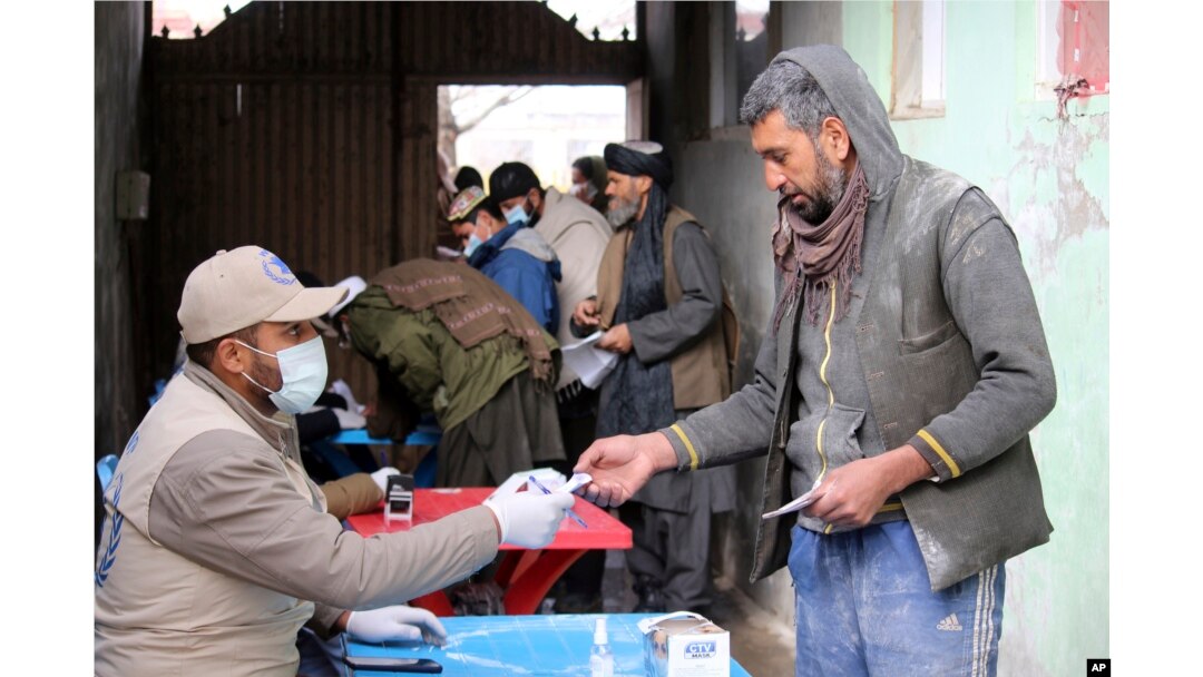Afghans wait to receive food rations organized by the World Food Program (WFP) in Pul-e-Alam, the capital of Logar province. eastern of Afghanistan, Jan. 18, 2022.