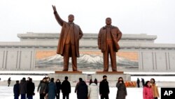 People visit the statues of former North Korean leaders Kim Il Sung, left, and Kim Jong Il on Mansu Hill in Pyongyang, North Korea, on the occasion of Lunar New Year holidays on Feb. 1, 2022.