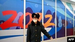 在2022年北京冬季奧運會開幕前，一名中國安保人員在張家口太子城站的“閉環管理”“泡泡”區域內引導到達的乘客。（2022年1月29日）
