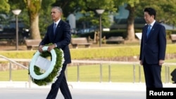 Presiden AS Barack Obama (kiri) didampingi PM Jepang Shinzo Abe saat meletakkan karangan bunga di monumen peringatan Perang Dunia II di Hiroshima, Jepang 27/5 lalu (foto: dok).