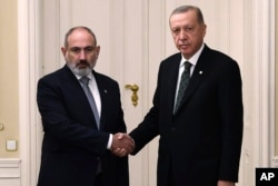 FILE - Presiden Turki Recep Tayyip Erdogan (kanan) dan Perdana Menteri Armenia Nikol Pashinyan berjabat tangan menjelang pertemuan di Kastil Praha di Praha, Republik Ceko, Kamis, 6 Oktober 2022. (Kepresidenan Turki via AP)