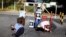 FILE - Mannequins depicting torture victims are left by demonstrators protesting against former Salvadoran army General Jose Guillermo Garcia prior to Garcia's arrival, at El Salvador International Airport in San Luis Talpa, Jan. 8, 2016.  