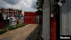 FILE - A Bangladeshi refugee stands at the entrance to his shack inside a quarters at the rural Ping Chi in Hong Kong's New Territories.