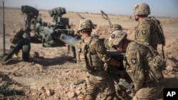 FILE - U.S. soldiers ready a howitzer to be towed into position at Bost Airfield in Afghanistan's Helmand Province in this June 10, 2017 photo provided by Operation Resolute Support.