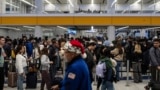 Travelers wait in line for security checks at the Los Angeles International Airport in Los Angeles, Dec. 24, 2024.