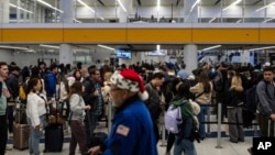 Travelers wait in line for security checks at the Los Angeles International Airport in Los Angeles, Dec. 24, 2024.