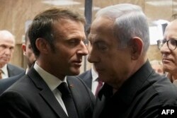 FILE - Israeli Prime Minister Benjamin Netanyahu (R) shakes hands with French President Emmanuel Macron (L) after their joint press conference in Jerusalem on October 24, 2023.