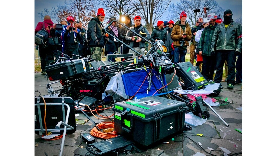 FILE - Supporters of U.S. President Donald Trump stand next to media equipment that was destroyed during a protest outside the Capitol in Washington, Jan. 6, 2021.
