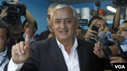 Kandidat Presiden dari Partai Patriot Guatemala, Otto Perez Molina, menunjukkan jari tangannya setelah memilih di TPS Guatemala City (11/9).