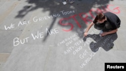 A man writes a message on the pavement in central Manchester, Britain, May 23, 2017. 