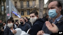File- Restaurant and bar owners bang plates together and chant at a demonstration against restaurant and bar closures in Marseille, southern France, Oct. 2, 2020.