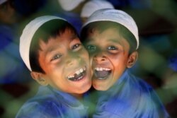 Rohingya refugee boys who study in an Islamic school smile as they react to the camera at a refugee camp in Cox's Bazar, Bangladesh, April 9, 2019